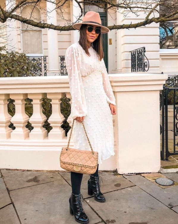 blogger wearing one of the white chicwish dresses which has long sheer bell sleeves with white polka dots on them and an a-line silhoeutte