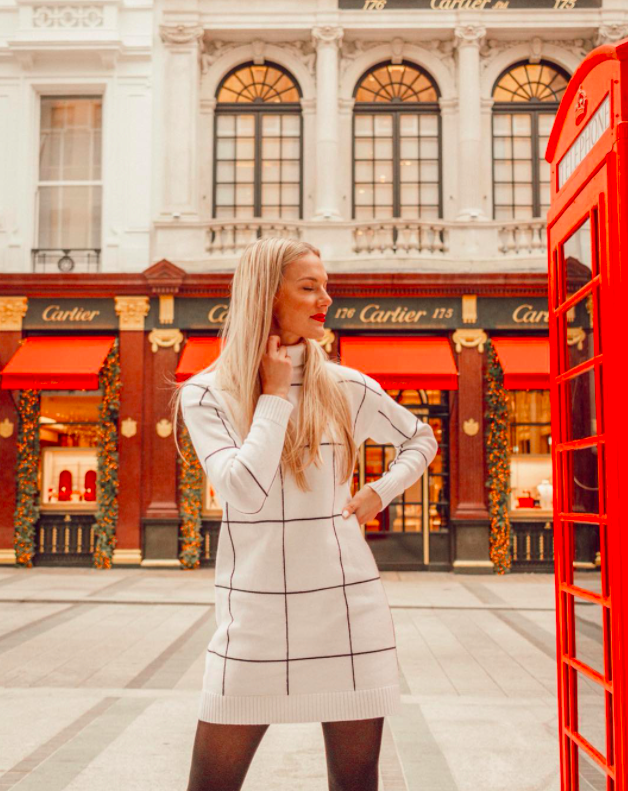 chicwish blogger wearing the white grid print turtleneck dress while standing in front of a storefront