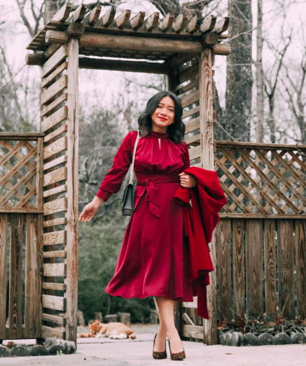 blogger wearing the red holiday dress with a red peacoat and heels